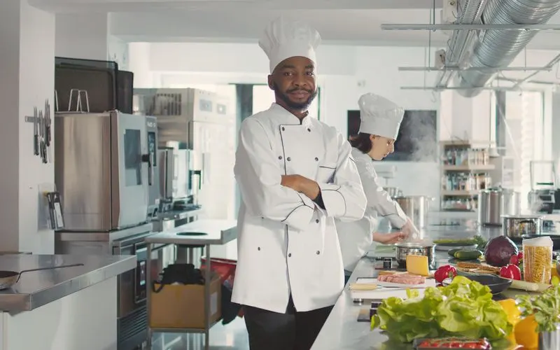 Chef in a crisp white uniform standing in a professional kitchen